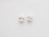 a pair of diamond earrings on a white background