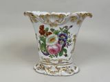 un vase blanc avec des fleurs sur une table