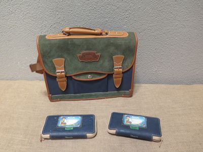 trois téléphones portables posés à côté d'un sac sur une table