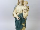 La statue de la Vierge Marie tenant un enfant porte une couronne.