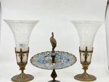 trois vases en verre posés sur une table, avec un oiseau perché dessus