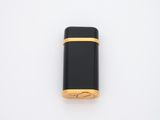 une image représentant un briquet noir et doré posé sur une surface blanche