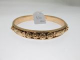 a close up of a gold bracelet with a tag on it