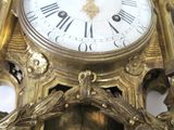 a gold clock on a white table with a black and white background