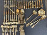 a lot of silver spoons and forks on the table