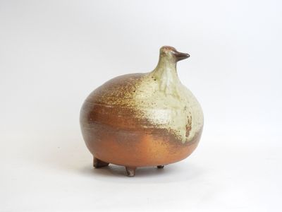 a brown and white vase with a bird on it