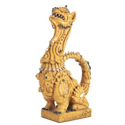 figurine de dragon jaune aux yeux et aux dents verts sur fond blanc