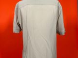 grey shirt on a mannequin stand against a red wall