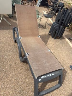 a chaise lounger on the ground in the yard