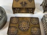 three small metal boxes sitting next to each other on a white surface