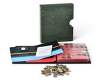 a green book with a red cover and a pile of coins