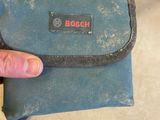 a hand holding a small blue bag with a logo on it
