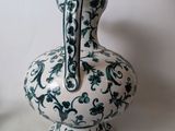 a white and green vase sitting on a table