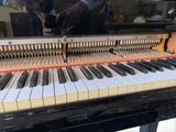 a close up of a piano with a person in the background