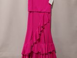 une robe rose suspendue à un cintre contre un mur