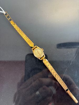 someone is taking a picture of a watch in a glass case