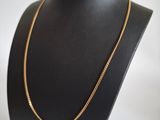 a black mannequin with a gold chain on it