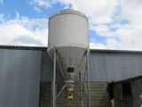 a man standing in front of a building with a silo