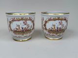 pair of porcelain cups with gold rims decorated with birds and flowers