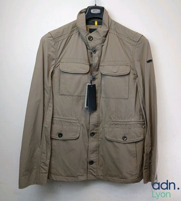 the jacket is hanging on a hanger on the wall