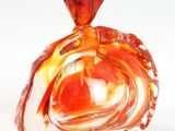 une bouteille en verre avec un bouchon rouge posée sur une table
