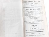 an old book opened to show the title of a french dictionary