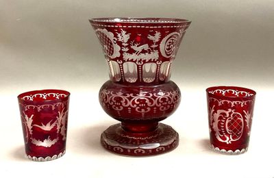 un vase rouge et deux verres posés l'un à côté de l'autre