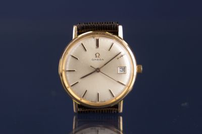 une montre-bracelet en or posée sur une surface bleue