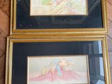 two framed paintings of a woman and a child on a wooden floor