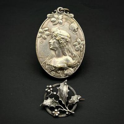 un gros plan d'une médaille et d'une broche posées sur une surface noire