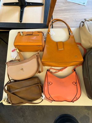 many bags and purses on a table in a store