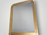 an image of a gold framed mirror hanging on a wall