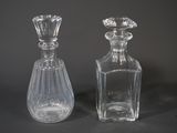 deux bouteilles en verre transparent posées l'une à côté de l'autre sur une table