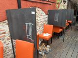 several orange chairs are lined up in front of a brick wall