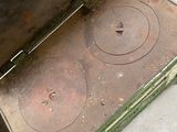 a person standing next to an old stove on the sidewalk