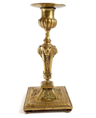 an image of a brass candle holder on a white background