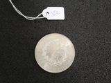 a silver coin with a price tag on a black surface