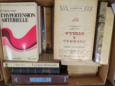 many books in a cardboard box on a shelf