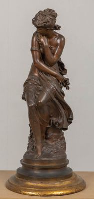 bronze statue of a woman holding a flower on a wooden base