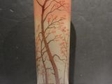 a glass vase with a painting of a tree on it
