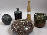 many different types of vases sitting on a table