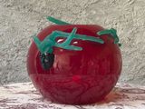 un vase rouge orné d'un dragon vert, posé sur une table