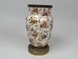 un vase posé sur un support sur une surface blanche