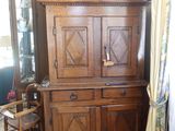 une armoire en bois dans une pièce où se trouve une horloge accrochée au mur