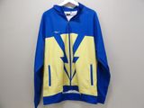 a blue and yellow nike jacket hanging on a wall