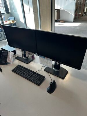 deux écrans d'ordinateur et un clavier sur un bureau