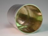 a close up of a metal cup on a white surface