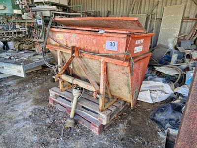 une benne à ordures posée sur une palette dans un garage