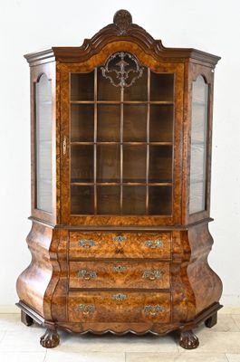 une vitrine ancienne avec des portes vitrées et des tiroirs