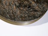 a bronze statue of a man riding a horse on a plate